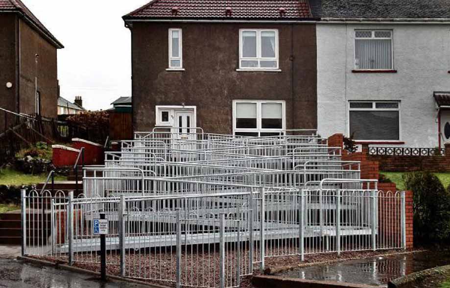 A house several metres above street level has an unusually long wheelchair ramp going back and fourth.